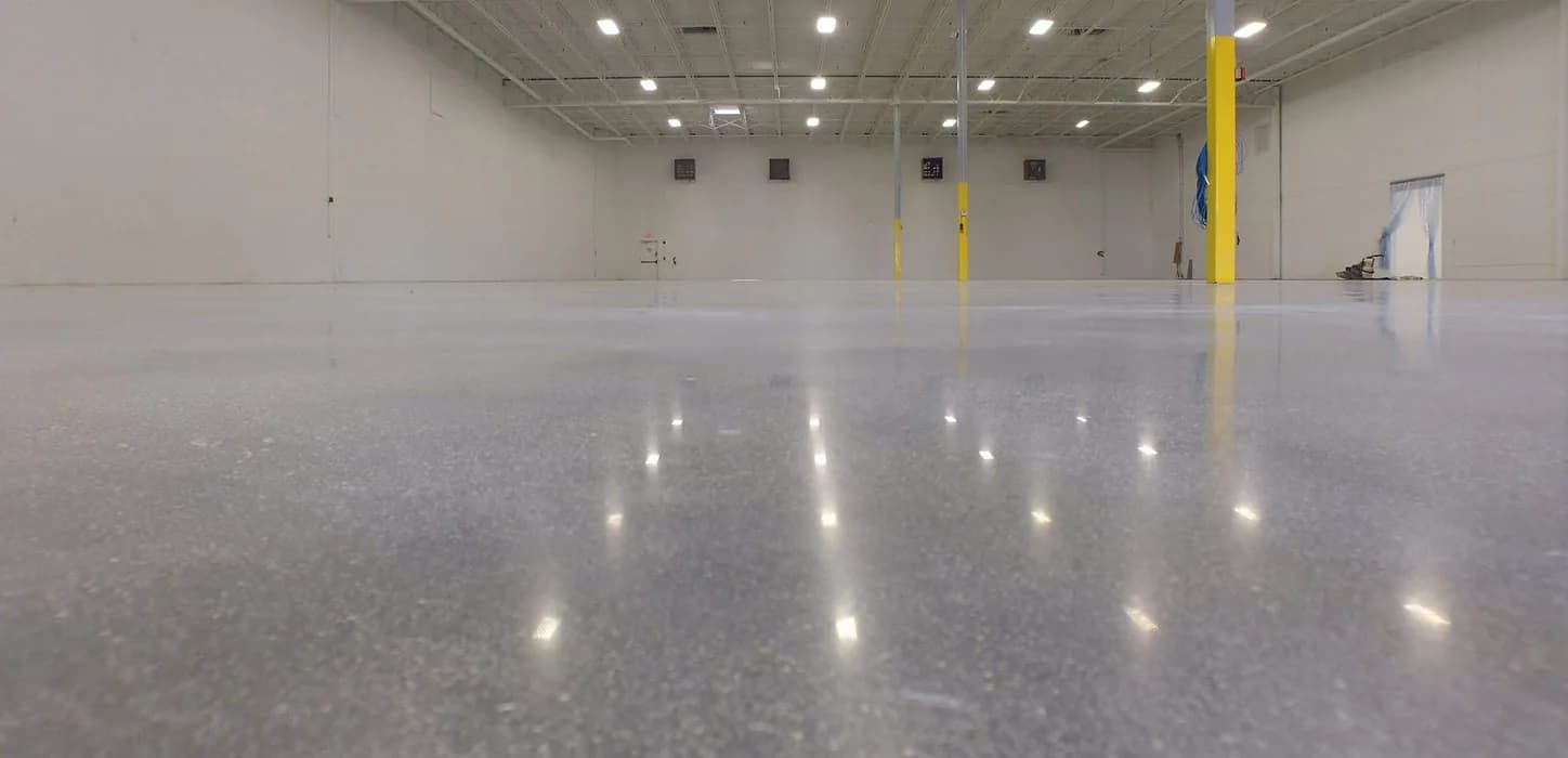 Polished concrete floor running the length of an empty warehouse bay