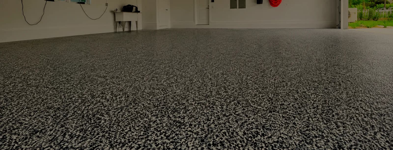 Flake-coated residential garage floor with the door open to the yard